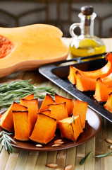 orange baked pumpkin, rosemary and olive oil on a kitchen table
