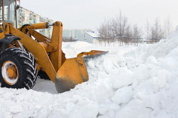 The bulldozer clears away snow drifts