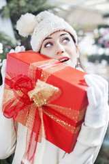 Obraz na płótnie Canvas Young woman shows her gift packs inside a Christmas shop