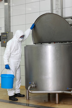 technician  with  bucket opening industrial process tank
