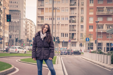 Young beautiful girl posing in the city streets