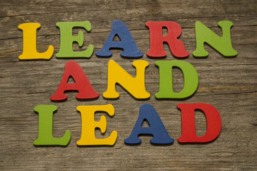 Learn and Lead text on a wooden background