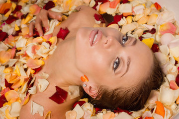 Obraz na płótnie Canvas Beautiful sexy woman in bath with flowers petals