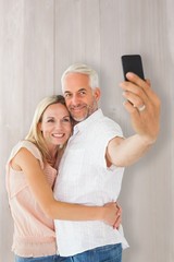 Composite image of happy couple posing for a selfie