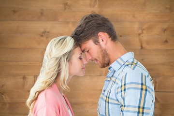 Composite image of attractive couple standing touching heads