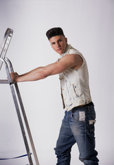 Attractive young man leaning on metal ladder