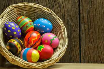 Easter eggs in basket and wood background