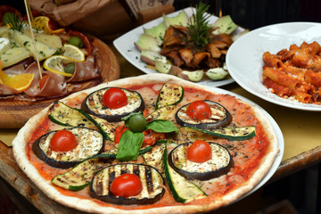 Pizza en ingredientes en una mesa de un restaurante.