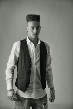 Trendy young man standing in studio shot wearing elegant vest
