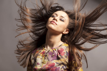 pretty girl with wind in her hair posing in the studio