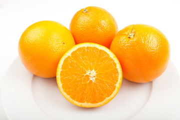drei saftige Orangen auf Porzellan Teller,