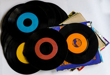 Old beat up 45s and their paper sleeves.