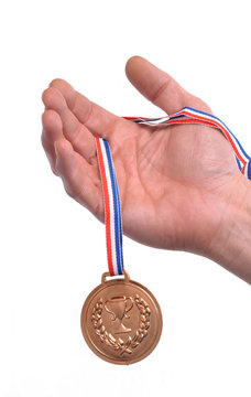 Vencedor celebrando triunfo sujetando una medalla de bronce.