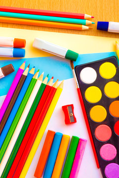Colorful art supplies on a wood background