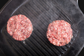 Fresh meat cutlets in a frying pan grill