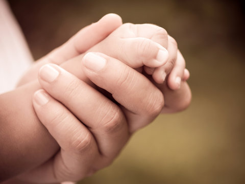 Closeup of mother and baby's hands with retro effect