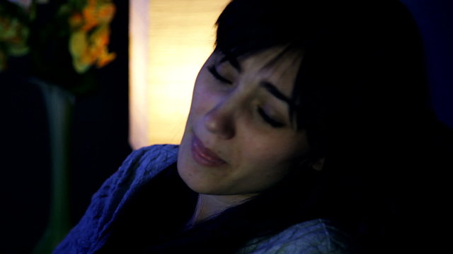 Sad desperate woman in bed crying alone closeup