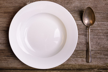 empty plate spoon on vintage rustic wooden background