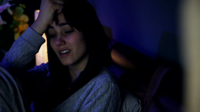 Sad desperate woman in bed crying alone