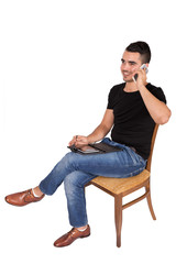 young man sitting on a chair looking at a tablet