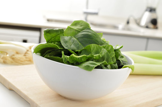 raw spinach leaves on the countertop of a kitchen