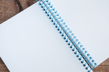 Open notepad with empty pages laying on a wooden table