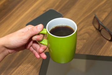 Woman Hand Holding Green Cup Full of Tea