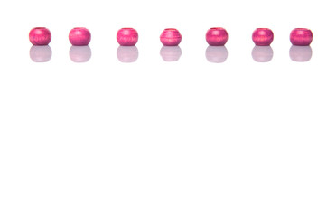 Pink round wooden beads over white background