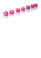 Pink round wooden beads over white background