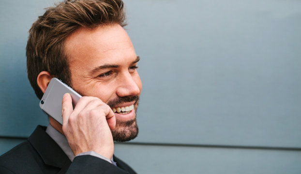 Young Businessman Talking by Phone in the Street