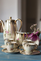 Tea cups with teapot on old wooden table.