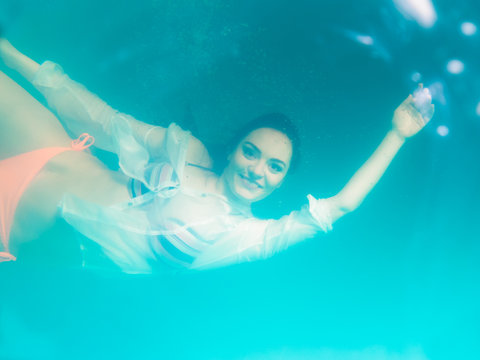 Underwater girl wearing bikini in swimming pool