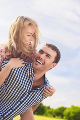 Portrait of Happy and Cheerful Young Caucasian Couple Piggybacki