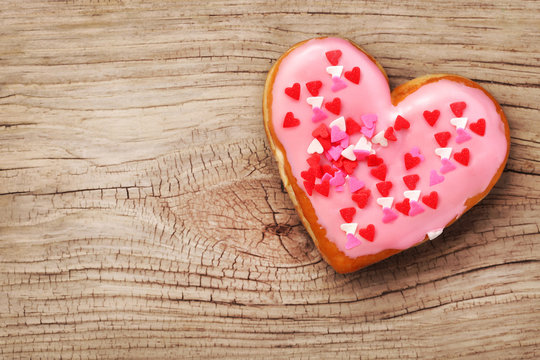Heart shaped donut on wooden background