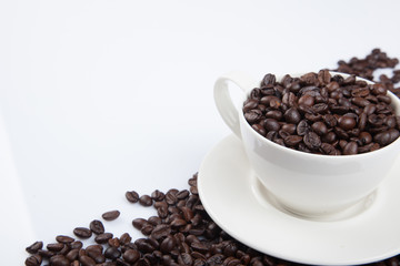Roasted coffee beans with a cup