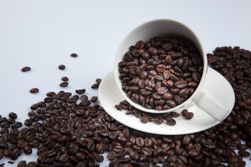 Roasted coffee beans with a cup