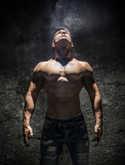Fototapeta na wymiar Shirtless Muscle Man Looking Up Into Bright Overhead Light