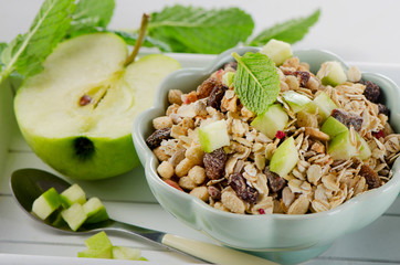Healthy muesli and green apple for breakfast in a bowl