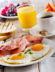 Fototapeta premium Breakfast with fried eggs, toasts, orange juice and coffee.