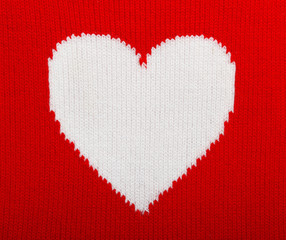Knitted white heart on red