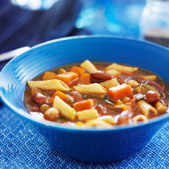minestrone soup in blue bowl close up