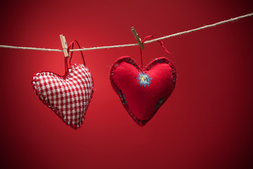 Colorful fabric hearts on red backgrounds