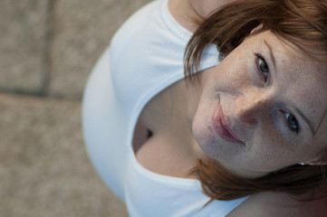 Schwangere Frau mit Sommersprossen von oben fotografiert