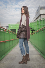 Beautiful young brunette posing on a bridge