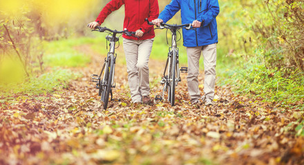 Fototapeta na wymiar Active seniors walking with bike