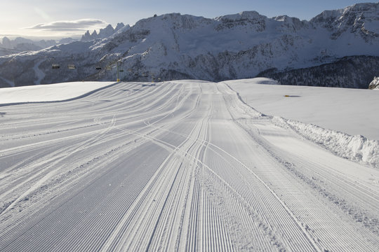 Fresh snow groomer tracks on a ski piste