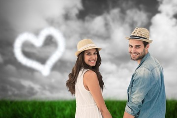 Fototapeta premium Happy hipster couple holding hands and smiling at camera