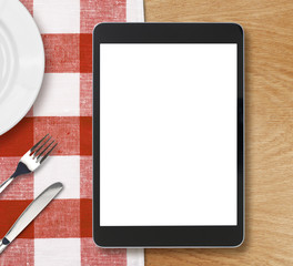 black tablet pc or ipad on dinner table with blank screen