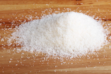 heap of coconut flakes on wooden plank