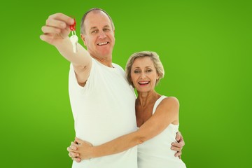 Mature couple smiling at camera with new house key